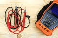 Digital multimeter with probes on a wooden table Royalty Free Stock Photo