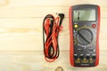 Digital multimeter with probes on a wooden table Royalty Free Stock Photo