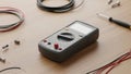A digital multimeter is surrounded by various electrical components and tools on a wooden surface, used for measuring voltage, Royalty Free Stock Photo