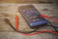 Digital multimeter and wiring on wooden table. special tools of technician for work with circuit and electrical. Royalty Free Stock Photo