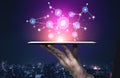 Digital Network Connection with Icons Representing Various Technologies Over a Tablet Display in a Night Cityscape Royalty Free Stock Photo