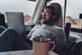 Digital nomad new modern job lifestyle with handsome adult man working and relaxing inside a camper van with beach and nature Royalty Free Stock Photo