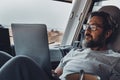 Digital nomad new modern job lifestyle with handsome adult man working and relaxing inside a camper van with beach and nature Royalty Free Stock Photo