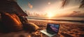 A digital nomad\'s confortable setting on a beach. A notebook in the sunset, close to the shoreline, sun, sky, horizon Royalty Free Stock Photo