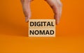 Digital nomad symbol. Wooden blocks with words Digital nomad on beautiful orange background, copy space. Businessman hand.