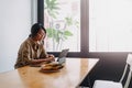 Digital nomad woman working online on the table of hostel while going abroad.