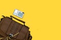 Digital photo silver camera and shoulder bag on yellow background