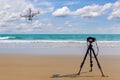 Digital professional camera stand on tripod photographing sea,Drone copter flying with digital camera