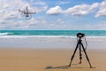 Digital professional camera stand on tripod photographing sea,Drone copter flying with digital camera