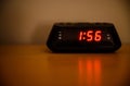 Digital radio alarm clock sitting on a table in a bedroom at night Royalty Free Stock Photo