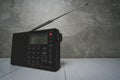 Digital radio receiver with elongated antenna gray concrete background.