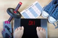 Digital scales with female feet on them and sign `ok!` surrounded by fitness accessories. Royalty Free Stock Photo