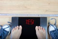 Digital scales with female feet on them and sign surrounded by gymshoes and measuring tape. Royalty Free Stock Photo