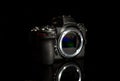 Digital sensor mirrorless camera body with reflection on dark background