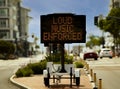 Digital sign stating Loud Music Enforced in an urban area in attempt to reduce loud music