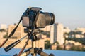 A digital SLR camera is mounted on a tripod. The shooting of the cityscape from the roof Royalty Free Stock Photo