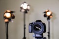 Digital SLR camera and three spotlights with Fresnel lenses. Manual interchangeable lens for filming Royalty Free Stock Photo