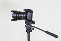 Digital SLR camera on a tripod with a removable manual lens on a gray background. Shooting in the interior Royalty Free Stock Photo