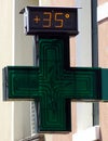 Digital street thermometer on a pharmacy sign displaying 35 degrees celsius. Very hot day concept Royalty Free Stock Photo