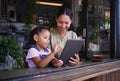 Digital tablet, cafe and mother with her child reading the online menu before ordering. Technology, internet and mom on Royalty Free Stock Photo