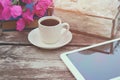 Digital tablet, colorful pencils and cup of coffee on old wooden table outdoor in the park