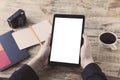 Digital tablet computer, isolation screen in male hands over cafe background - table wooden plancs, cup of coffee, nootbook, penci Royalty Free Stock Photo