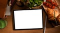 Digital tablet computer mockup with breakfast on working table Royalty Free Stock Photo