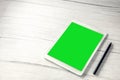 Digital tablet computer with pen and isolated green screen white wooden desk top view, copy space for film,movie, moving image Royalty Free Stock Photo