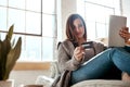 Digital tablet, credit card and woman on a sofa for online shopping, ecommerce and payment while relaxing. Girl, couch