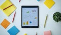Digital tablet displaying financial charts and graphs on white surface Royalty Free Stock Photo