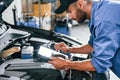 Digital tablet in hands. Auto mechanic working in garage. Repair service Royalty Free Stock Photo