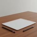 A digital tablet with a large screen lies on a wooden surface. Two stylus pens are place Royalty Free Stock Photo