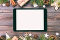 Digital tablet mock up with rustic Christmas wood background decorations for app presentation. top view with copy space. Toned Royalty Free Stock Photo