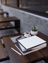 Digital tablet mockup on modern outdoor wood table. Outdoor coffee shop seating area