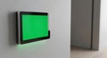 Wall mounted digital tablet with green screen display in a modern interior setting Royalty Free Stock Photo