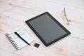 Digital tablet, notepad, pen, glasses on a table Royalty Free Stock Photo