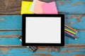 Digital tablet on pens, staple pins, color pencils and sticky notes Royalty Free Stock Photo