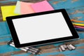 Digital tablet on pens, staple pins, color pencils and sticky notes Royalty Free Stock Photo