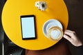 Digital tablet on top of cafe table and a woman hand holding cup of coffee Royalty Free Stock Photo