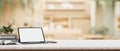 A digital tablet white-screen mockup with a wireless keyboard on a table in a cosy coffee shop