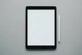Digital tablet and white stylus on gray background, clean and modern setup Royalty Free Stock Photo