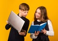 Digital technology for learning. Small children use new technology at school. Little girl and boy hold IT book and Royalty Free Stock Photo