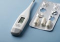 Digital thermometer displaying 38.5Â°C and a blister pack with three Royalty Free Stock Photo