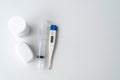 Digital thermometer, fingertip oximeter, pill bottle, nasal syringe tube, on white background, flat lay style, home medical