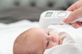 Digital thermometer highlights mother& x27;s protective instinct. Concept of modern maternal care methods