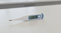 Digital thermometer on a light-colored countertop displaying \