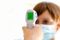 Digital thermometer scannering a boy`s body temperature, new normal back to school Royalty Free Stock Photo