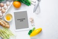 Digital touch screen tablet with fresh vegetables and kitchen utensils on background, top view Royalty Free Stock Photo
