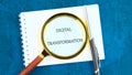 Digital transformation and digitalization technology. DIGITAL TRANSFORMATION in a clean notebook through a magnifying Royalty Free Stock Photo