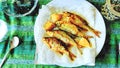 Watercolorstyle representing a plate of small fried fish with lemon ready to serve